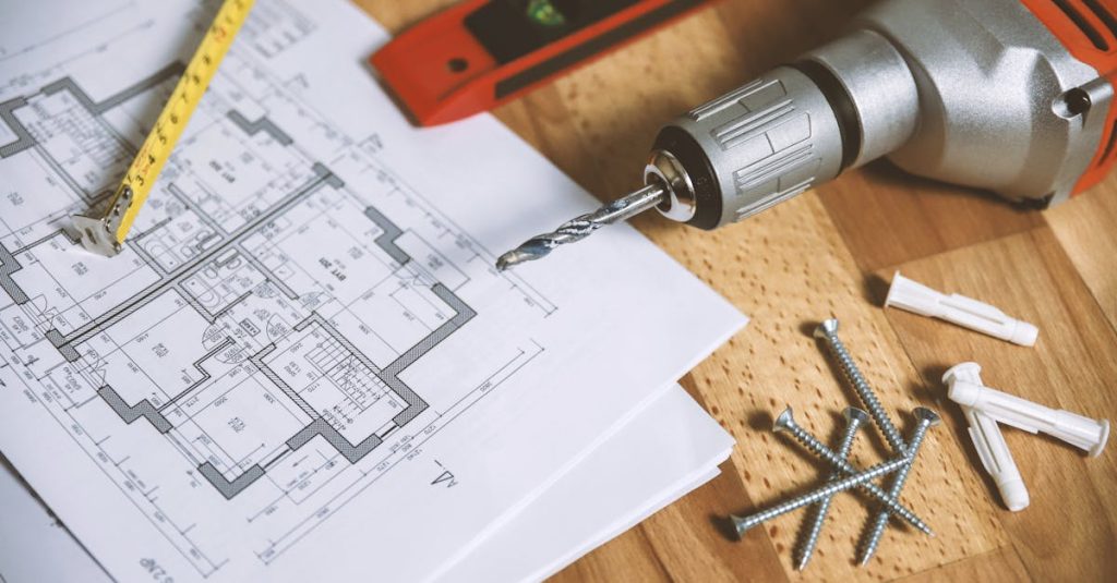 pexels photo 834892 834892 Close-up of construction blueprint with tools like drill and screws on a wooden table.